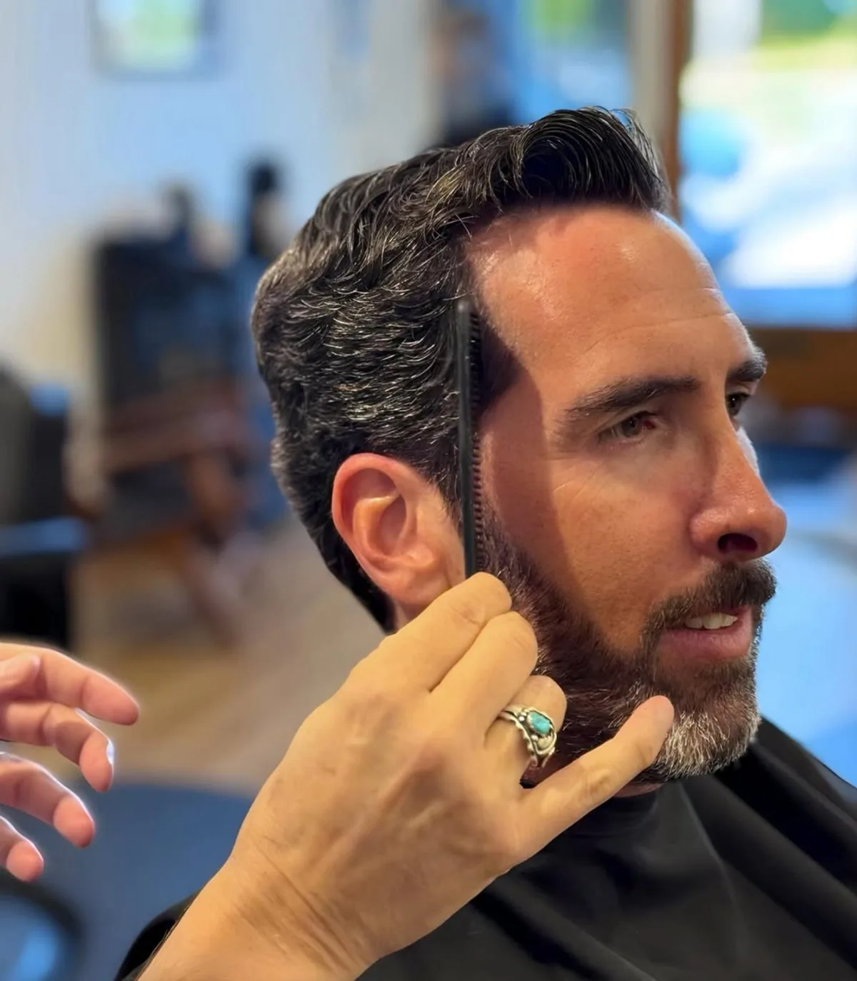 Finished men's haircut — silver side-part with a clean taper