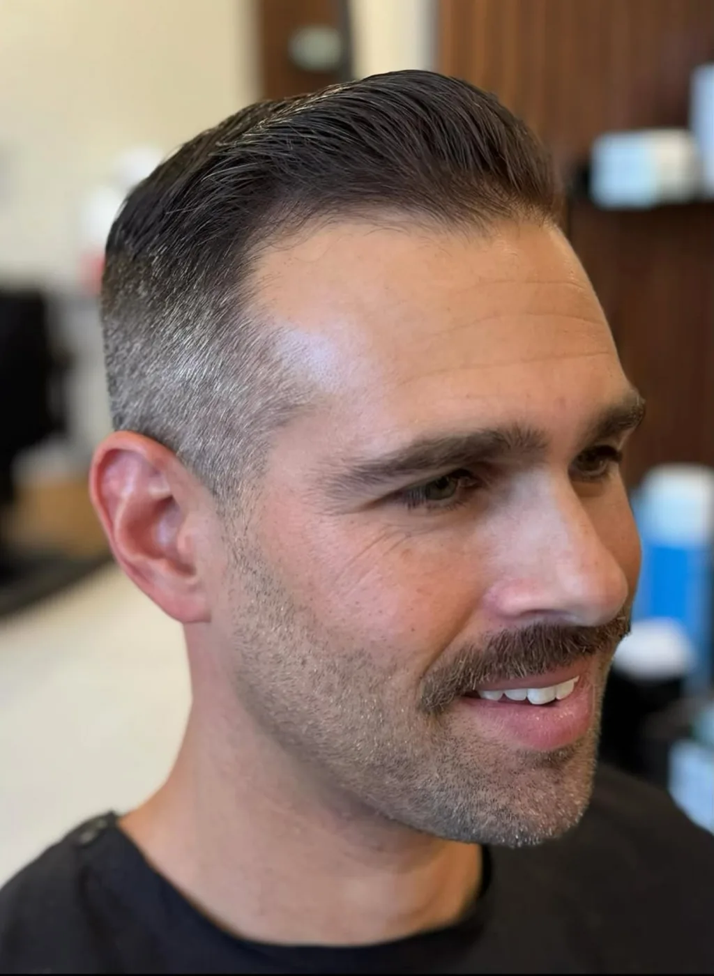Finished men's haircut — textured dark hair with a full beard