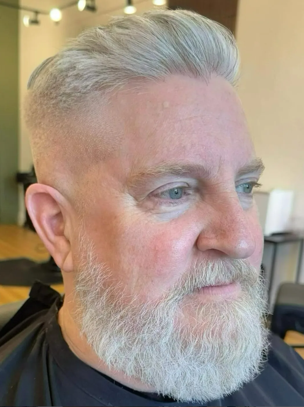 Finished men's haircut — silver pompadour with a full grey beard